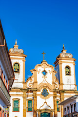 Wall Mural - Front of historic baroque style church and surrounding colonial houses in the city of Ouro Preto in Minas Gerais