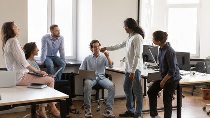 Wall Mural - Happy diverse office friends giving fist bump, sitting, standing in circle on meeting, sharing good ideas, approving job result, teamwork achieve. Employees, interns, coworkers expressing support