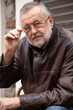 © glebchik - Handsome elderly man in glasses and leather jacket close-up