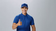 © MP Studio - Cheerful man in a blue polo shirt and cap, giving a thumbs-up, likely representing a friendly and approachable delivery service professional.