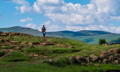 Basotho man with basotho blanket and basotho hat walking in the mountains in Semonkong, Lesotho, Southern Africa