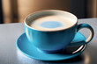 Uma xícara azul com o pires, com cappuccino cremoso, sobre um balcão de bistrô.