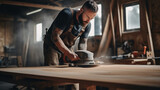 Fototapeta  - Male carpenter using sander on a piece of wood in a carpentry workshop. ai generative
