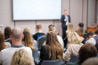 © Anton Gvozdikov - Back view of businesswoman attending presentation with diverse participants in conference hall
