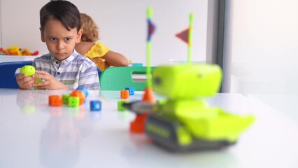elementary school student studying technology, using joystick control panel with automatic remote ca