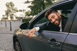 © Yaroslav Astakhov - Smiling businessman in suit is riding behind steering wheel of car and looks camera