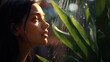 © IndigoElf - Beautiful young female face with clear skin is hidden behind large green aloe vera leaves. Natural moisturizing cosmetics with natural aloe extract.