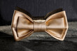 Stylish pale yellow bow tie on gray textured table