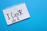 Fototapeta  - Motivation concept. Changing phrase from I Can't Do It into I Can Do It by crossing out letter T on light blue background, top view. Space for text