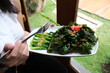 fried cooked green vegetables called kailan served on a restaurant dining table using a white plate