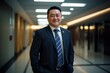 © Fokasu Art - Friendly Chinese man in his forties in a blue suit standing in a modern hospital hallway.