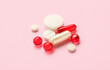 Different medical pills on pink background, closeup