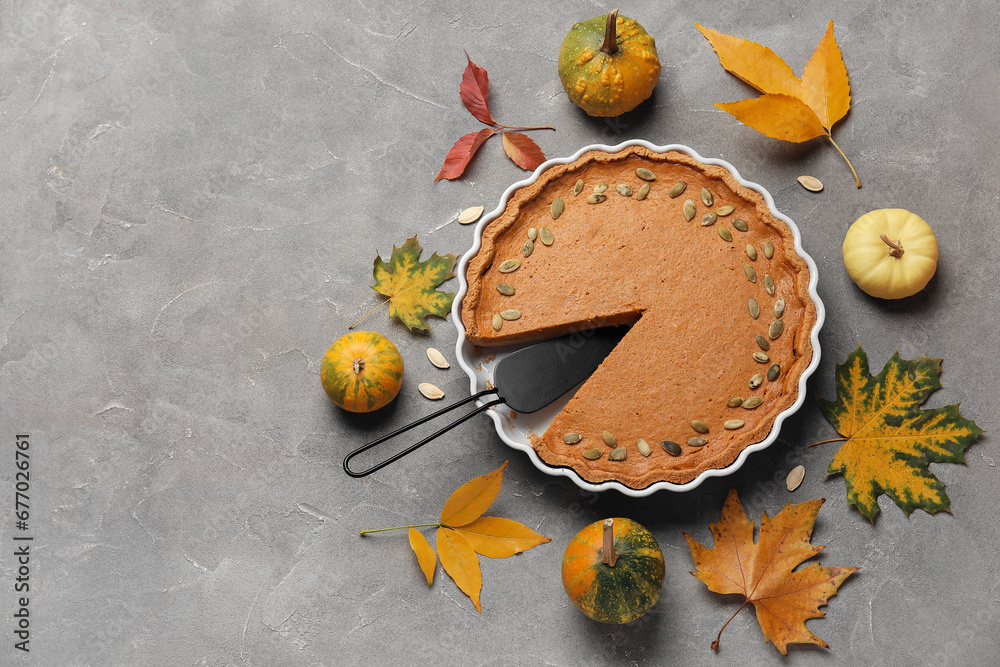 Autumn composition with tasty pumpkin pie on grey background