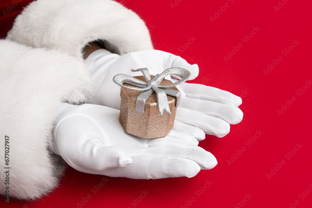 Santa Claus with Christmas gift box on red background