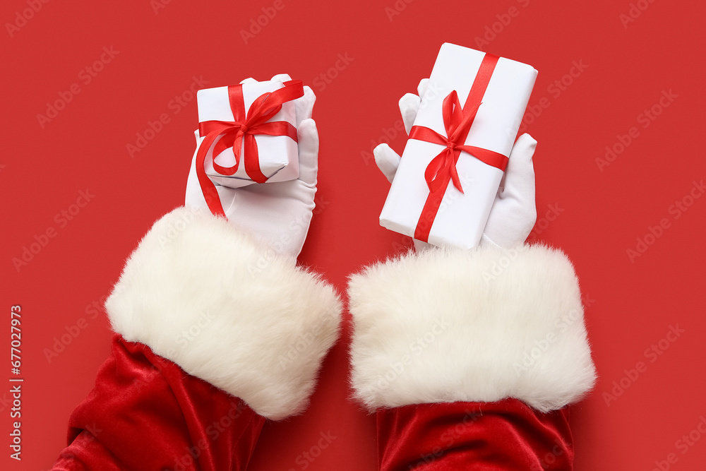Santa Claus with white gift boxes on red background