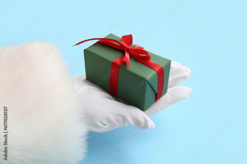 Santa Claus with green gift box on blue background