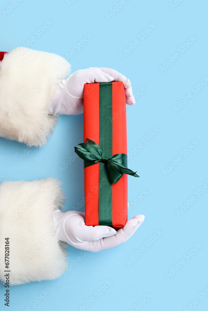 Santa Claus with gift box on blue background