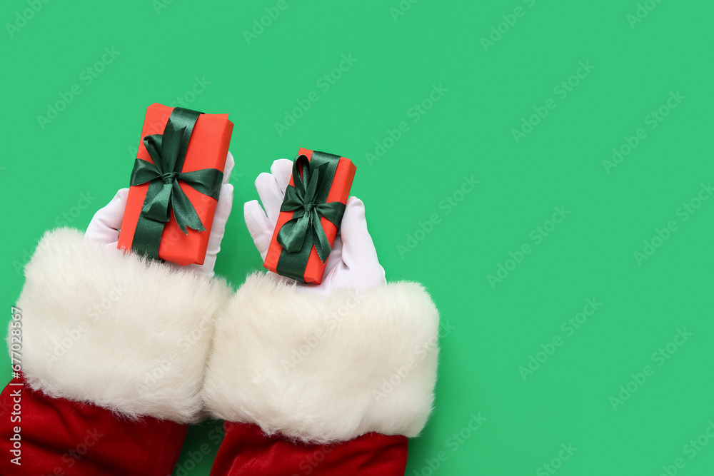 Santa Claus with gift boxes on green background