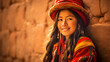 Peruvian young woman in traditional clothing on an Inca wall in Chinchero, Cusco, Peru