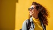 © yj - A relaxed posture of a female student with a backpack slung over one shoulder, exuding casual confidence against a bold yellow background. generative AI