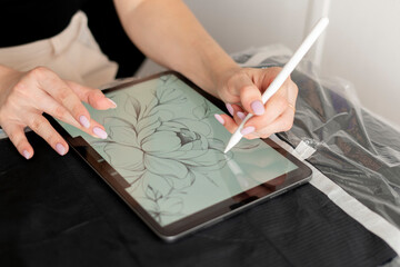 Wall Mural - a young female artist designing new tattoo sketch on a tablet