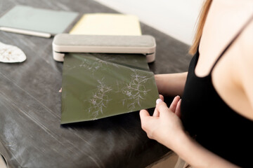 Wall Mural - a young woman prints new tattoo sketch on a paper using a printing machine in studio