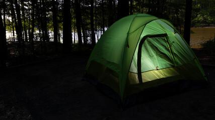 Wall Mural - Green tent in a dark forest