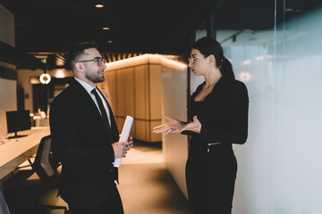 Wall Mural - Positive colleagues discussing business strategy in office