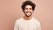 © Ai Studio - Smiling young man with curly hair, neutral t-shirt on peach backdrop