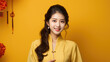 © hakule - Portrait of smiling vogue Asian girl with Chinese golden traditional clothing, solid color background