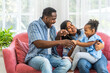 © Art_Photo - Portrait of enjoy happy love black family, play, having fun, daughter, parenthood, care, african american father and mother with little african girl child smiling moments good time at home
