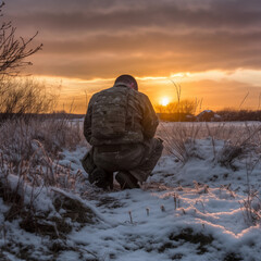 Wall Mural - Photograph of a soldier kneeling after praying at sunrise.