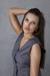 © Tatyana - Sexy luxury woman in grey masculine costume, grey wall background. Beautiful brunette girl standing ans smiling. Portrait of lady in great shape. Big lips and stylish woman model