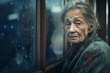 Sad old lonely elderly woman looking through the window. High quality photo