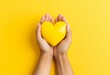 hands holding a yellow heart