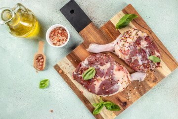 Wall Mural - Raw Duck Legs, Uncooked Poultry Meat on a wooden board on a light background top view. copy space