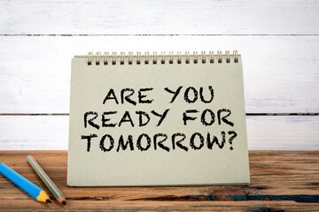 Are You Ready For Tomorrow. Green notepad on wooden texture table and white background