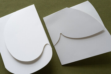 two folded paper shapes on green