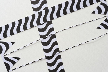 Wall Mural - abstract cut paper shapes (ribbons or banner cutouts) with black and white patterns on blank paper