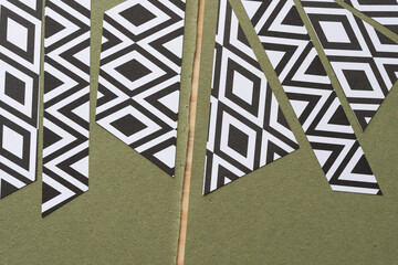 Canvas Print - cut geometric paper shapes with black and white rhomboid forms on rough green paper