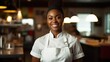 © Fred - Smiling black female chef in her restaurant women and black owned business concept