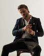 © Viorel Sima - cool elegant man in tux with open collar shirt looking down and fixing rings