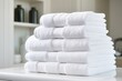 A stack of white towels sitting on top of a counter