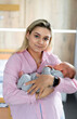 © Vadim - Young pretty woman with newborn baby. Adorable young mom holding little child.
