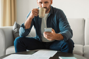 Poster - man sipping coffee browsing offers on phone in living room