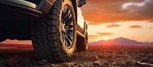 Close Up Photo Of A Large Offroad Wheel With A 4x4 Car Set Against A Sunset And Mountains Representing The Travel Concept Copy Space Image Place For Adding Text Or Design