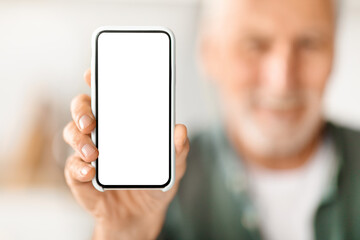 Senior man showing blank smartphone with empty white screen to camera