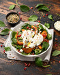 Roasted butternut squash salad served with poached eggs, spinach, nuts and pomegranate seeds