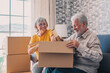 © Daniel - Relaxed mature married couple in love resting on couch among paper cardboard boxes, taking break, pause, hugging, talking, enjoying being in new home. Real estate concept.