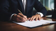 © Reza - business man signing contract document on office desk